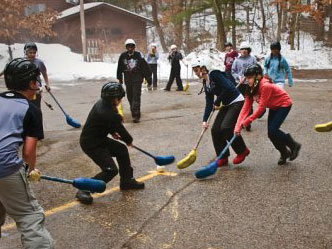A group of kids playing broomball in the winter