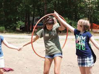 Two kids playing with a hoola hoop
