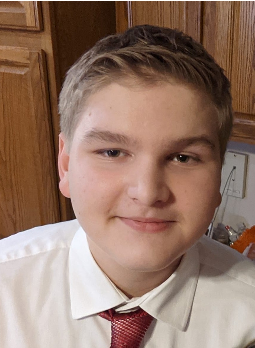 a young man wearing a white shirt and red tie smiling